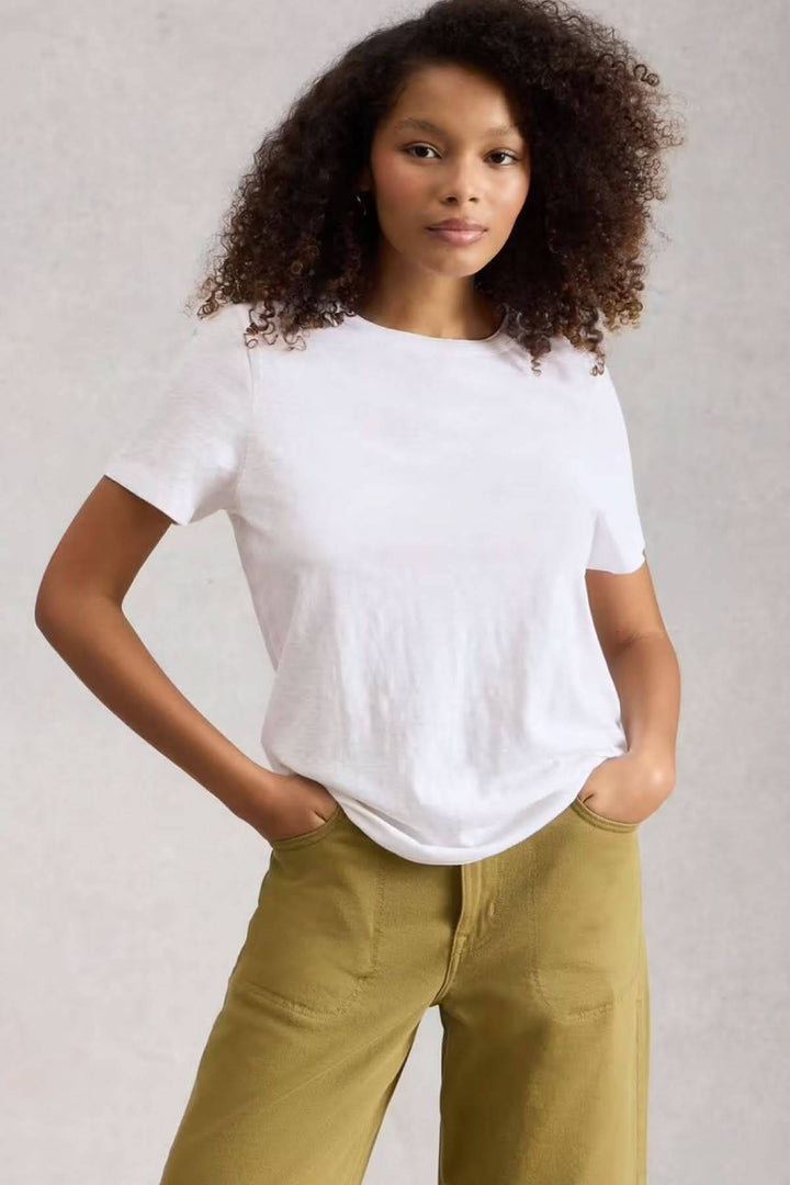 T-shirt Clara à col rond et manches courtes porté par un modèle, coupe droite et fluide, encolure ronde, style épuré et confortable.