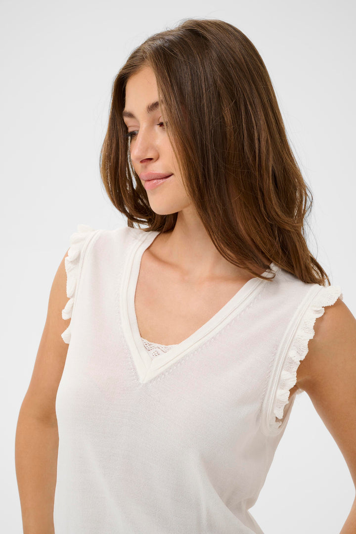 Femme portant le T-shirt Desten, sans manches, avec une encolure en V et détails volantés, style féminin et léger.