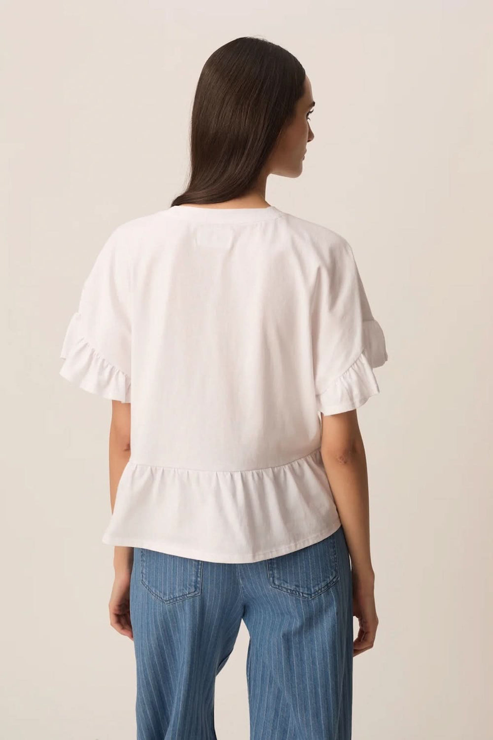 Femme portant T-shirt JESSICA avec manches courtes à volants et coupe évasée, vue arrière, assorti à un jean décontracté.