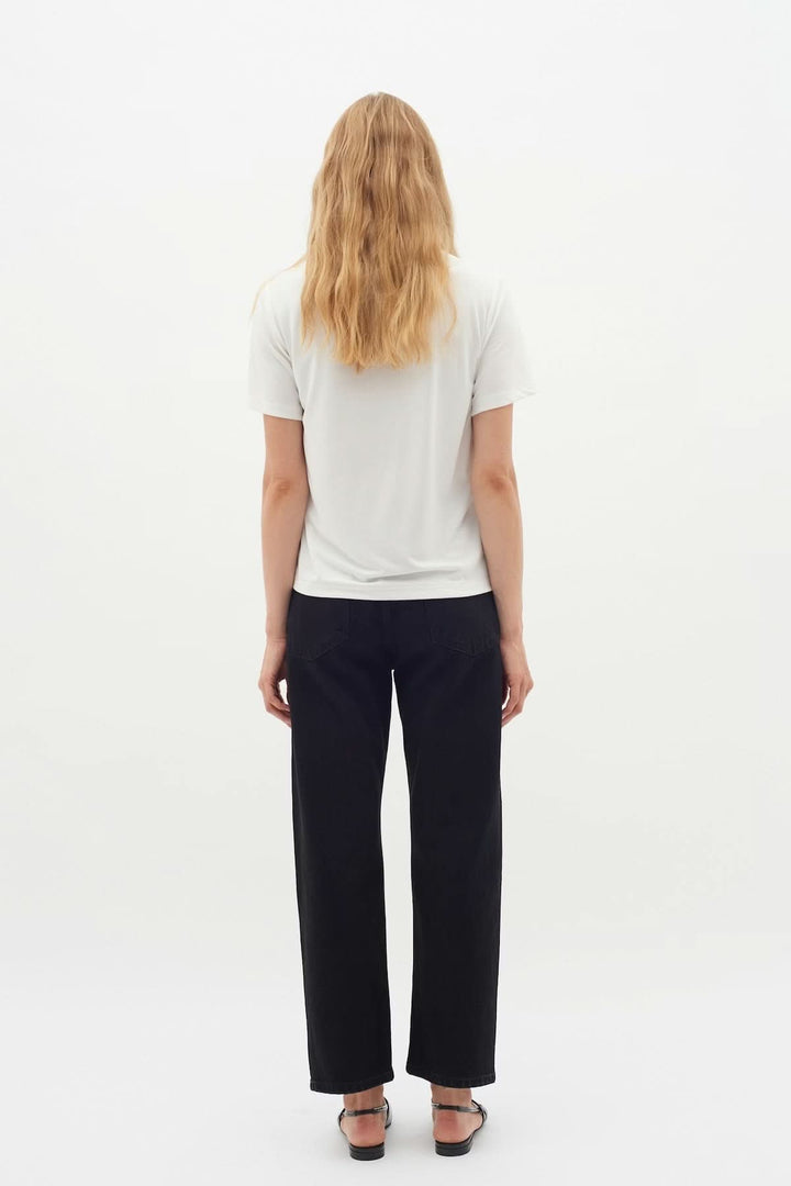 Vue arrière du T-shirt Liliana blanc, coupe droite, manches courtes, porté par un modèle, parfait pour une garde-robe minimaliste.