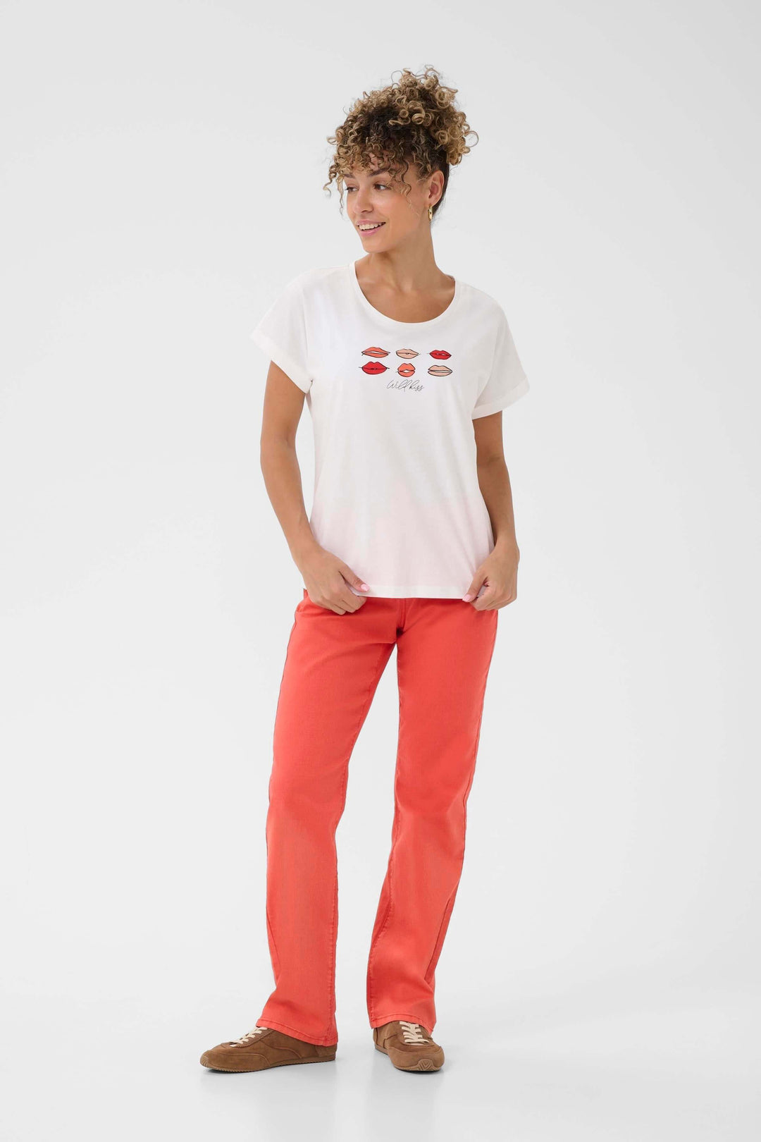 T-shirt Lumilla blanc avec imprimé lèvres colorées, esprit casual et féminin, porté avec un pantalon rouge pour un look décontracté.