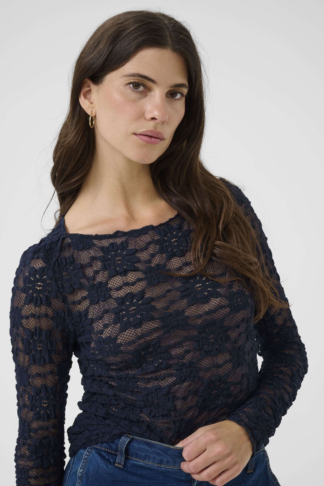 T-shirt Maddie en dentelle bleu marine à manches longues, mettant en valeur une silhouette féminine et élégante.