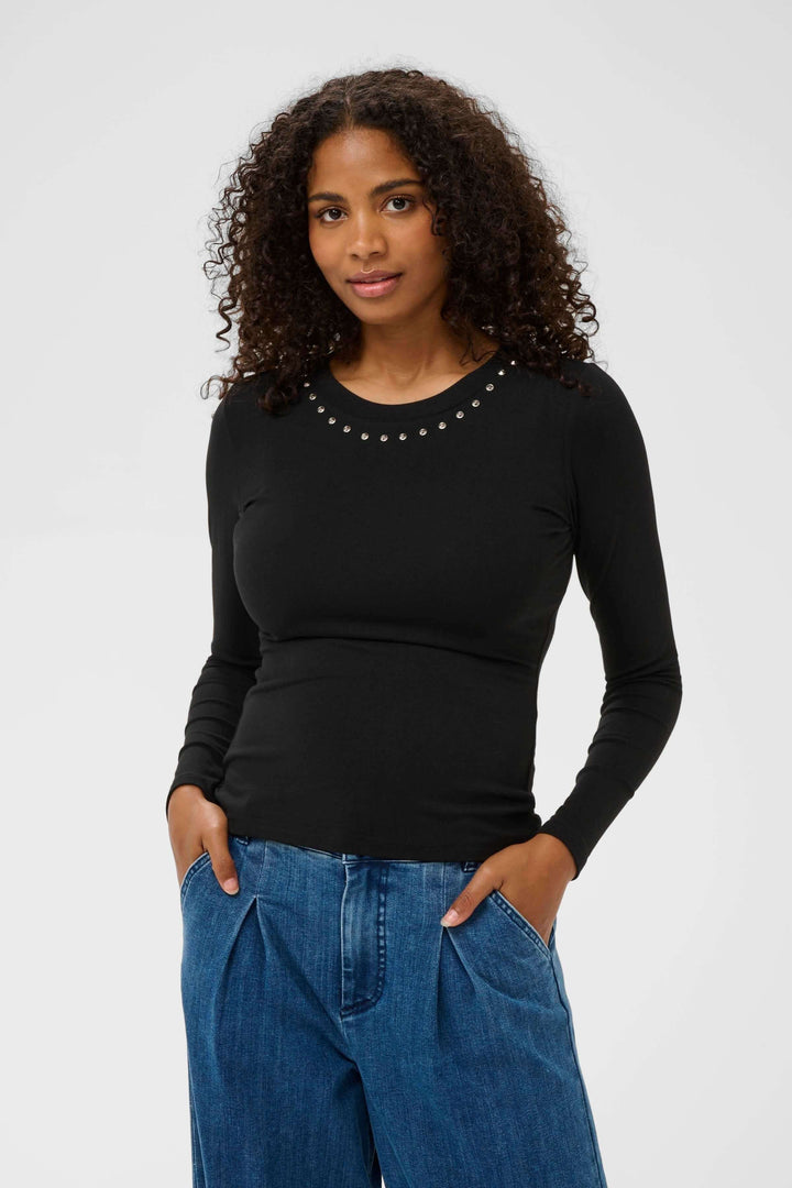 Femme portant le T-shirt Marty à manches longues ajusté avec détails décoratifs à l'encolure, idéal pour un style soigné.