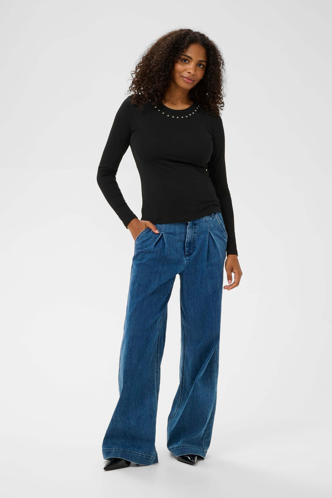 Femme portant le T-shirt Marty à manches longues ajusté et décoratif, style élégant et décontracté.