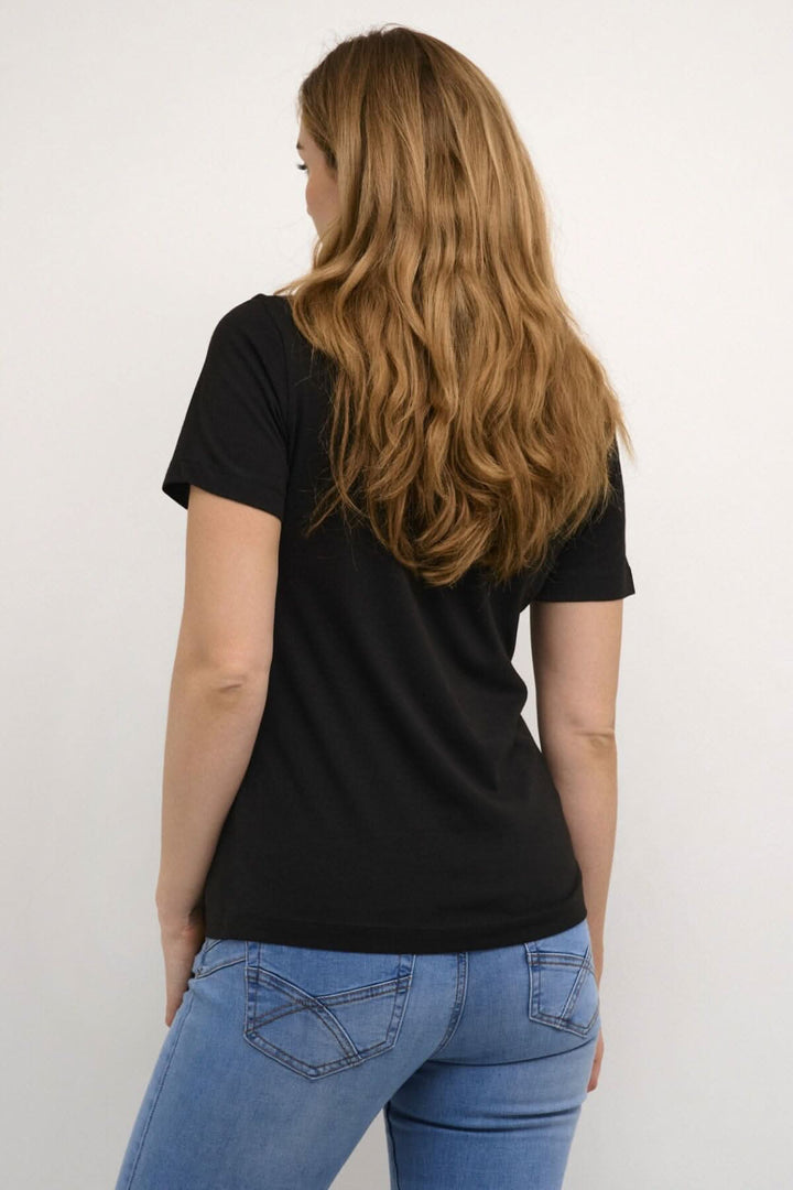 Femme portant un t-shirt Naia noir à encolure V et manches courtes, vu de dos, avec un jean.