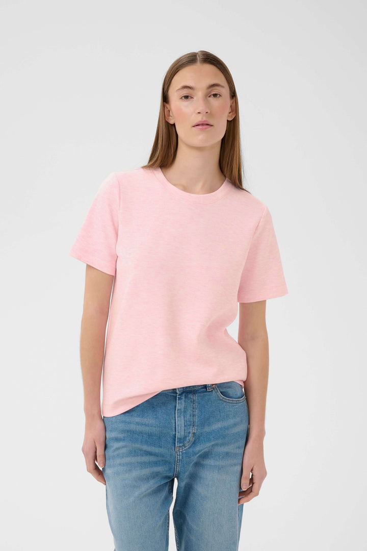Femme portant le T-shirt Vincent rose avec coupe droite et allure minimaliste, idéal pour un style décontracté et polyvalent.