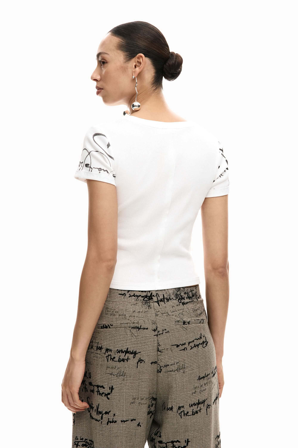 Femme portant un T-shirt ajusté avec lettrage, vue arrière, style moderne et féminin.