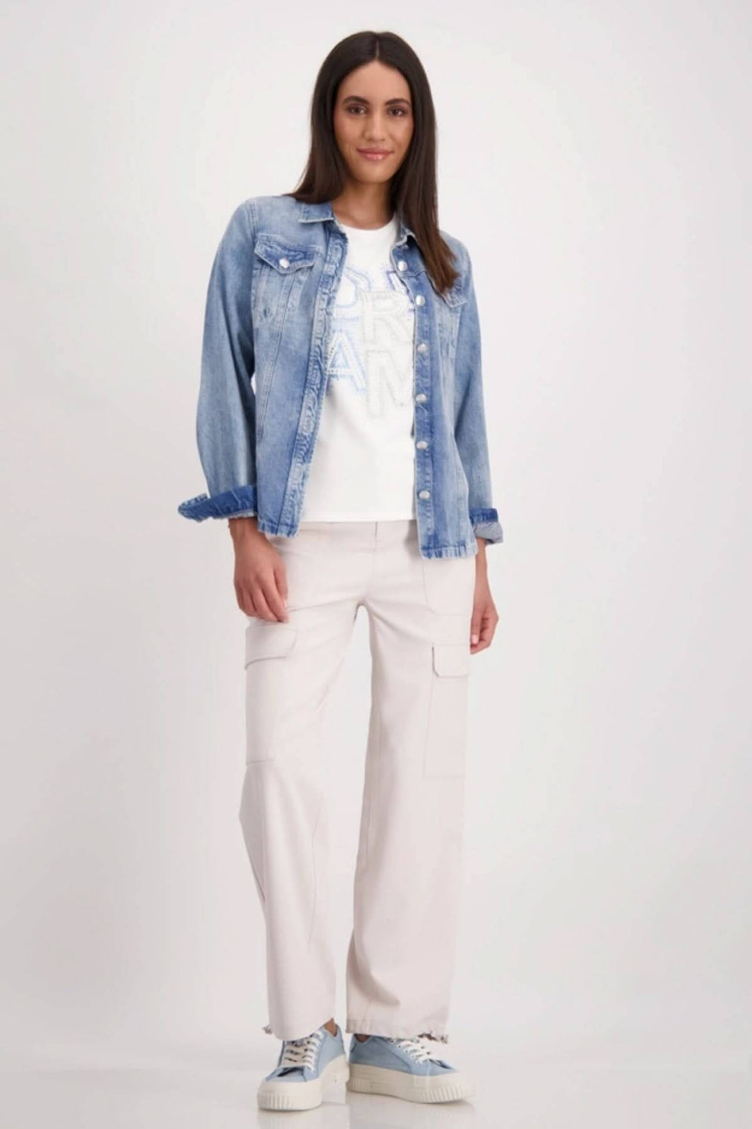 Modèle portant un t-shirt舒肉刨 de qualité avec denim bleu et pantalons cargo, style décontracté.
