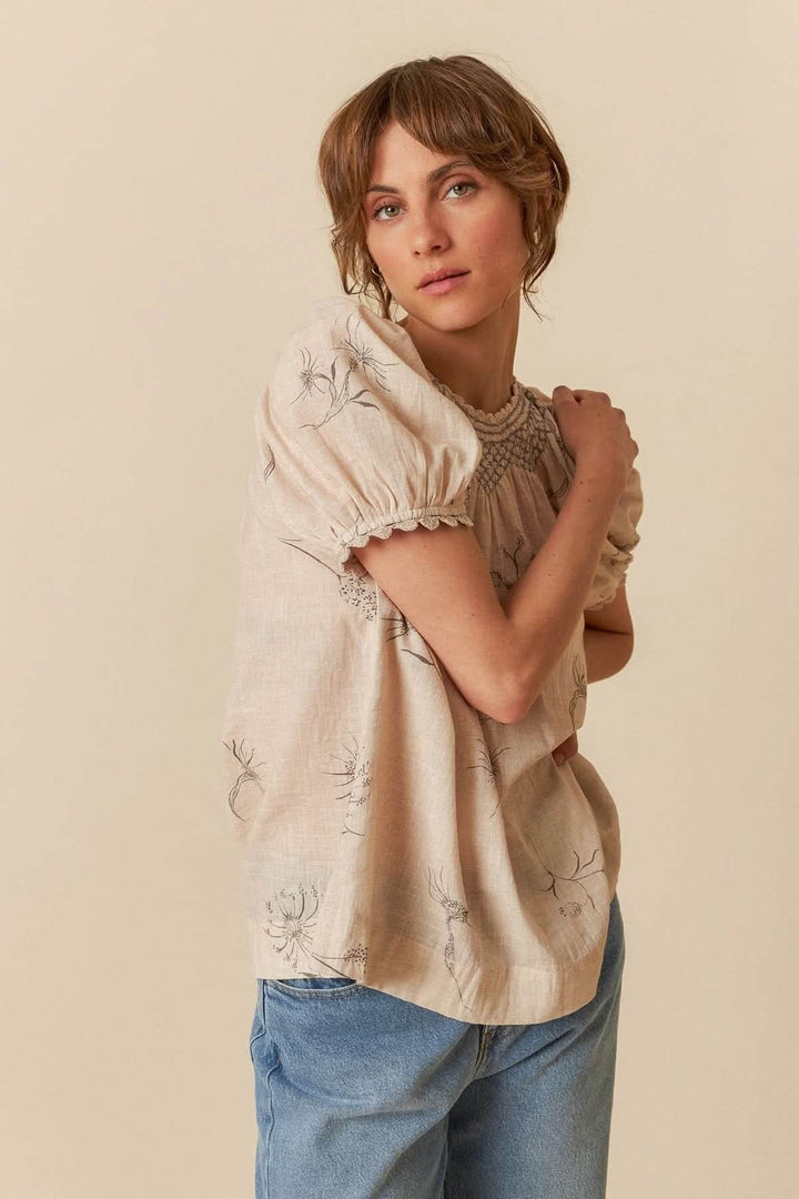 T-shirt avec détails au crochet, col smocké, manches bouffantes et imprimé floral léger, porté avec un denim.