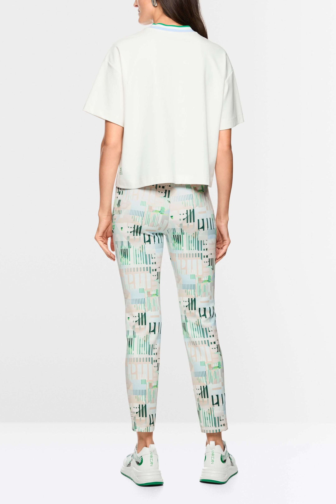 Femme portant un t-shirt ample avec détails en forme de cœur et à rayures, assorti à un pantalon imprimé, vue de dos.