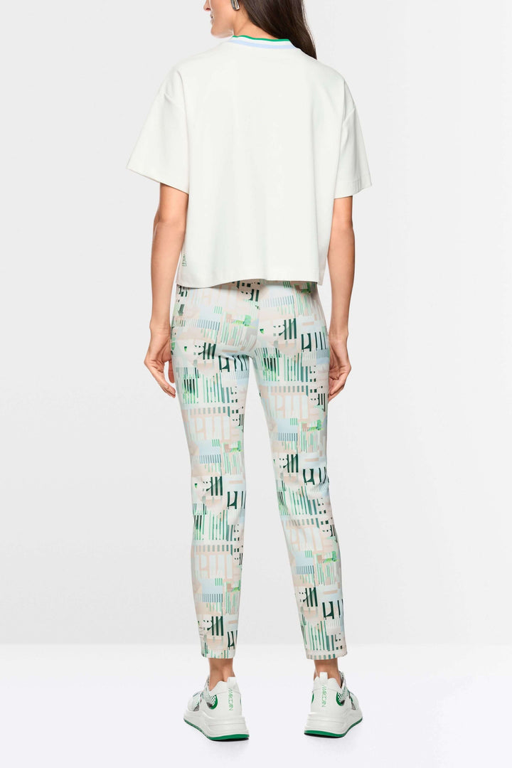 Femme portant un t-shirt ample avec détails en forme de cœur et à rayures, assorti à un pantalon imprimé, vue de dos.