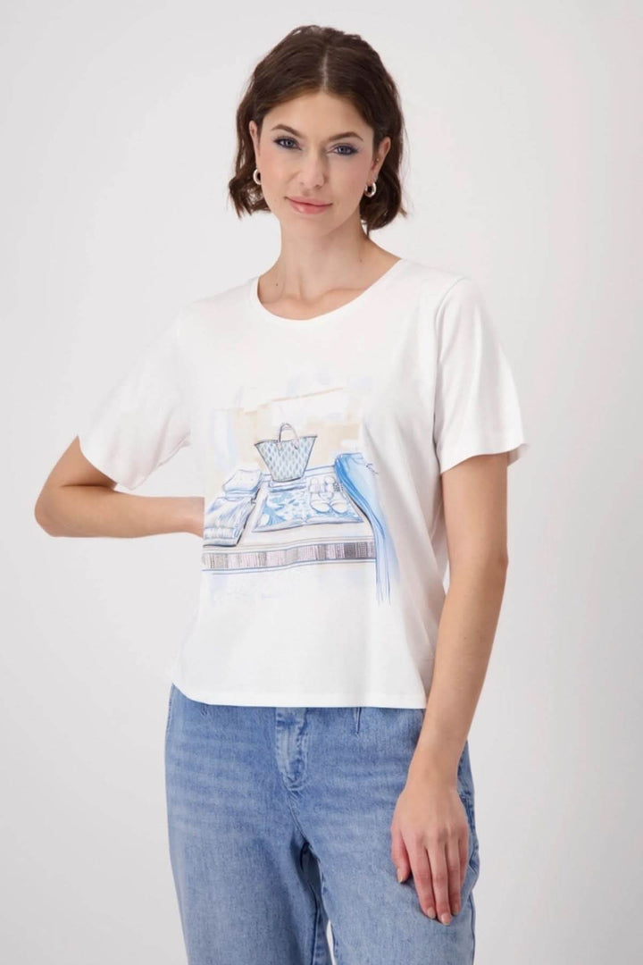 T-shirt en coton blanc avec imprimé élégant et strass, porté avec jean clair pour un look chic et décontracté.