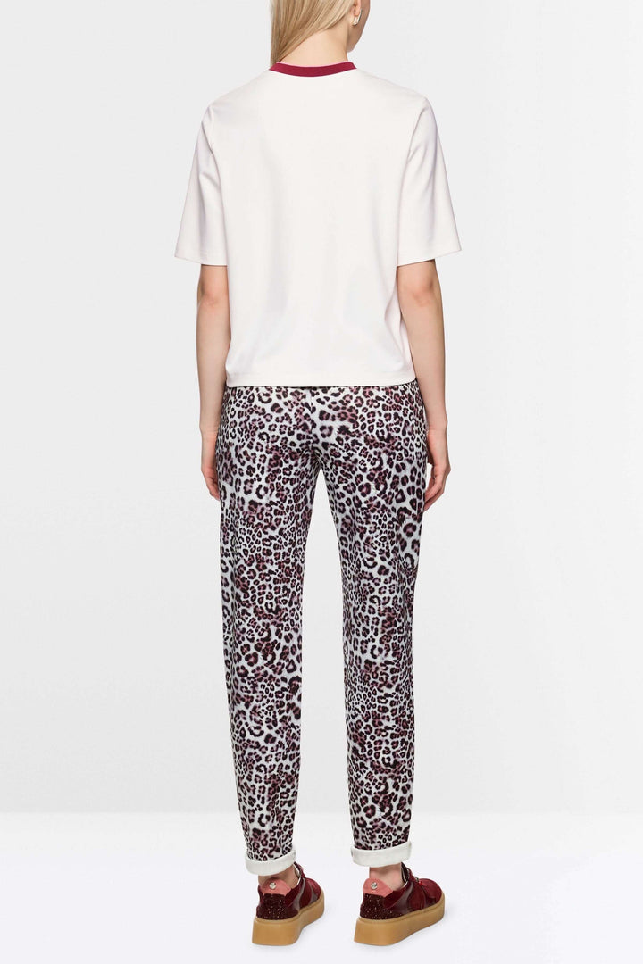 T-shirt classique blanc à col contrasté et logo Marc Cain, manches courtes, porté par un mannequin de dos, style décontracté, confortable.