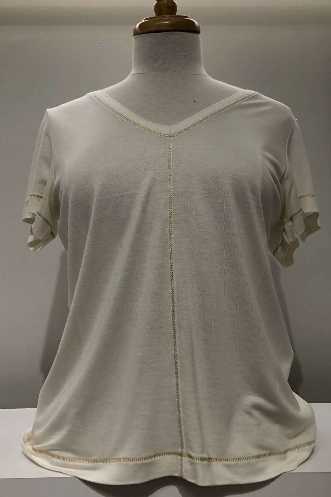 T-shirt col V blanc avec manches tombantes et surpiqûre dorée pour un look élégant et décontracté.