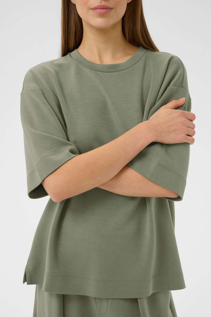 Femme portant le T-shirt Pannie ample et fluide pour un look décontracté et moderne.
