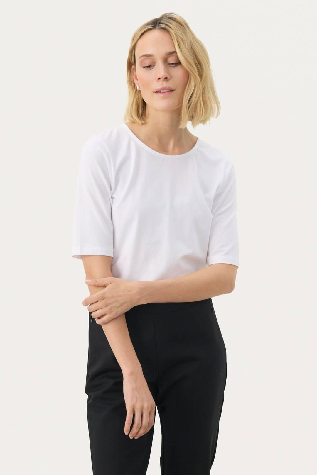 Femme portant le T-shirt coupe droite Nemi, design minimaliste et silhouette épurée, idéal pour un look quotidien moderne.