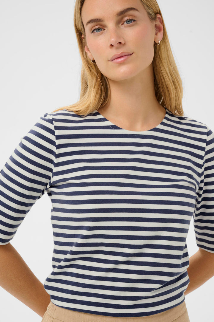 Femme portant un t-shirt à rayures marines et blanches avec coupe droite Nemi, design minimaliste et look épuré.
