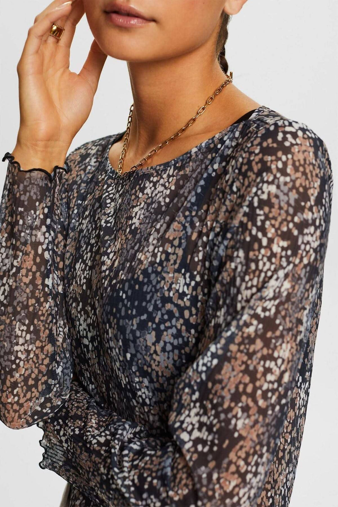 T-shirt en mesh plissé à motifs floraux, manches longues, semi-transparent, coupe près du corps.