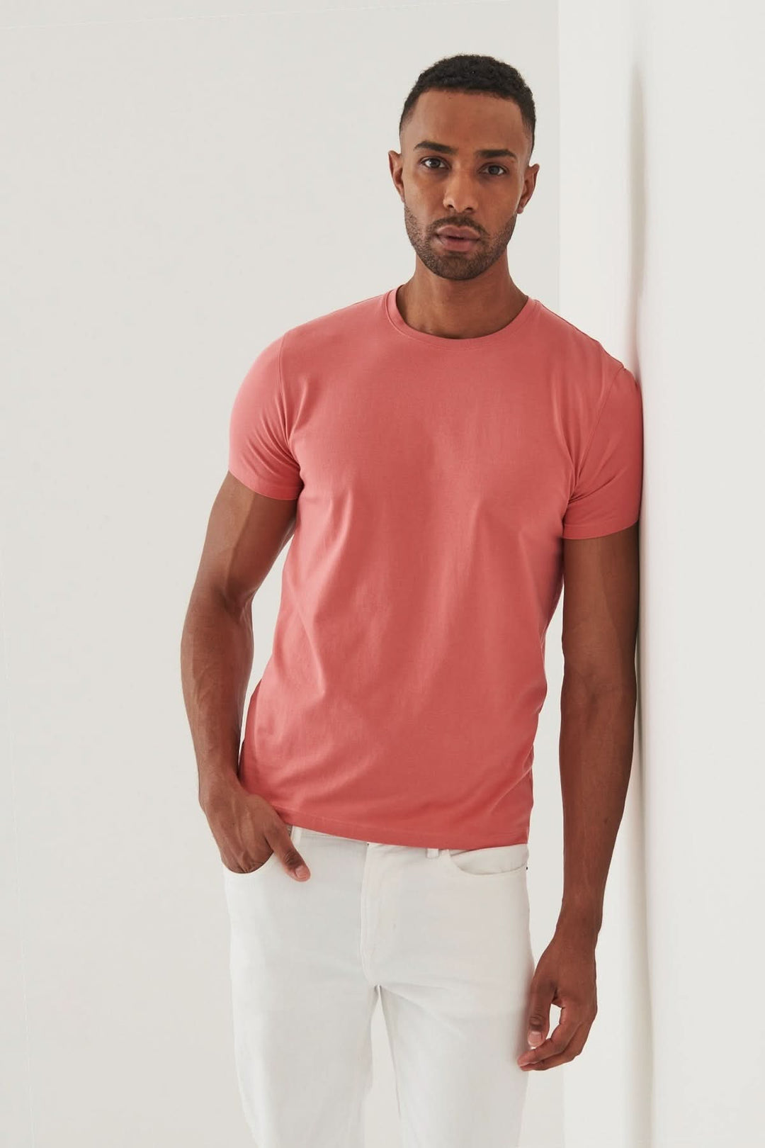 Homme portant un T-shirt en coton Pima rose, association parfaite de confort et de sophistication.