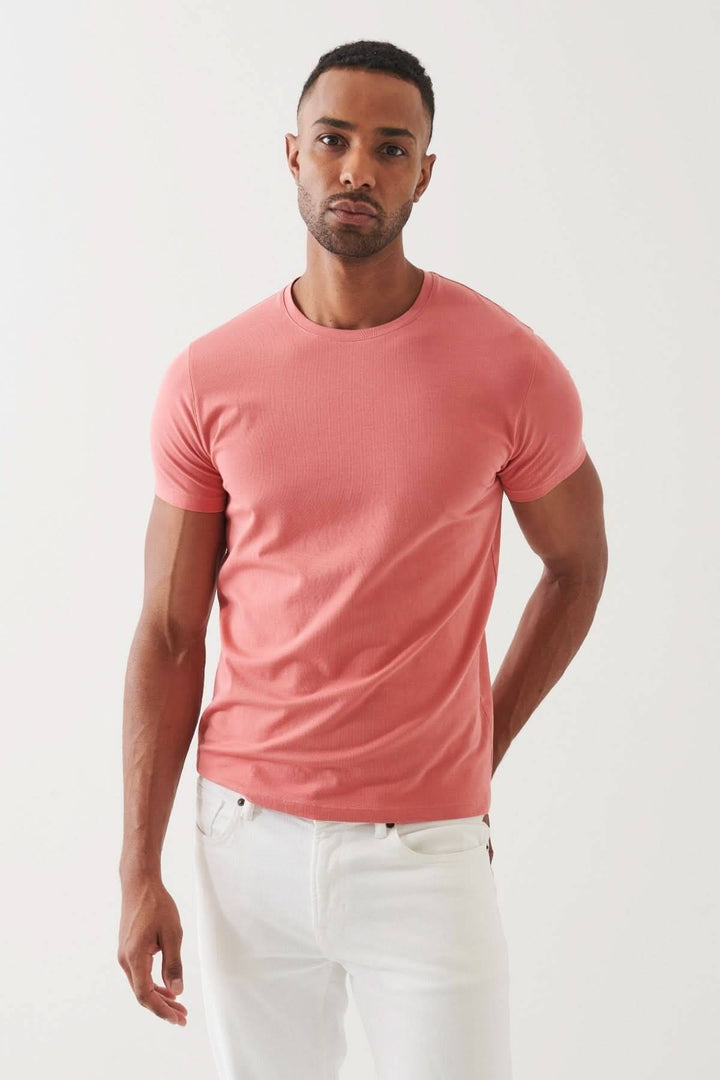 Homme portant un T-shirt en pima coton rose, alliant confort et élégance décontractée.