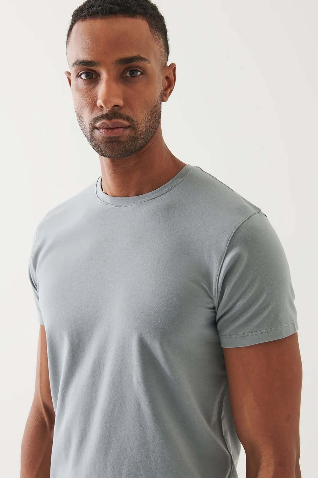 Homme portant un T-shirt en pima coton bleu, exprimant confort et élégance.