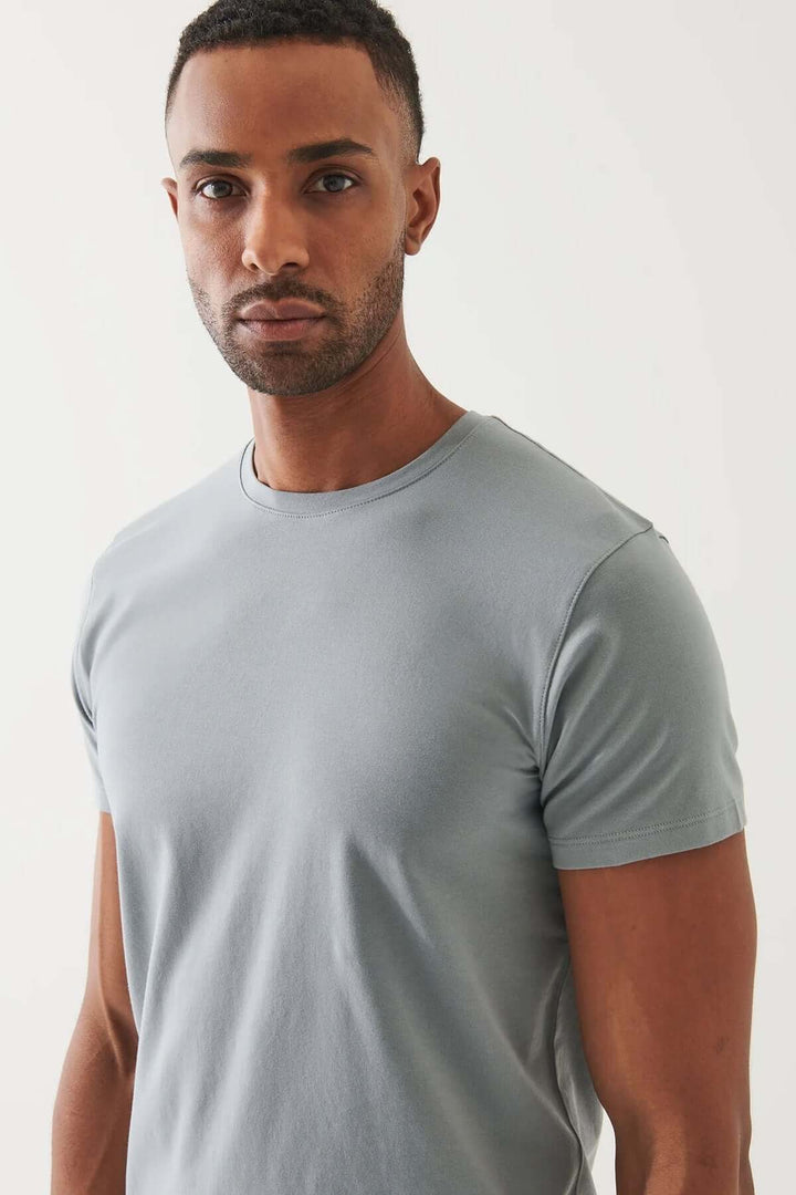 Homme portant un T-shirt en pima coton bleu, exprimant confort et élégance.