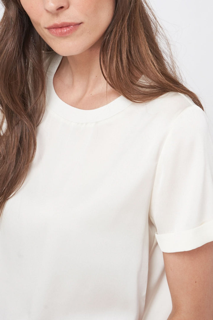 Femme portant un t-shirt en soie extensible, encolure ronde, style minimaliste, manches courtes à revers.