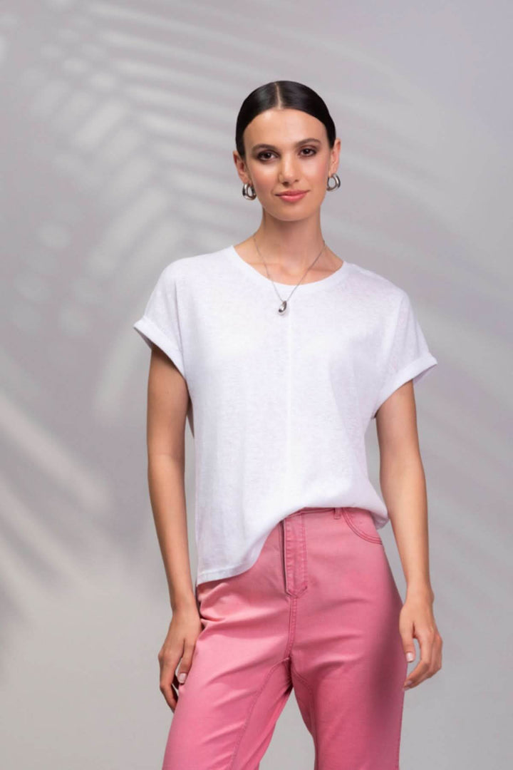 T-shirt encolure ronde blanc porté par une femme avec un pantalon rose, style décontracté et moderne.