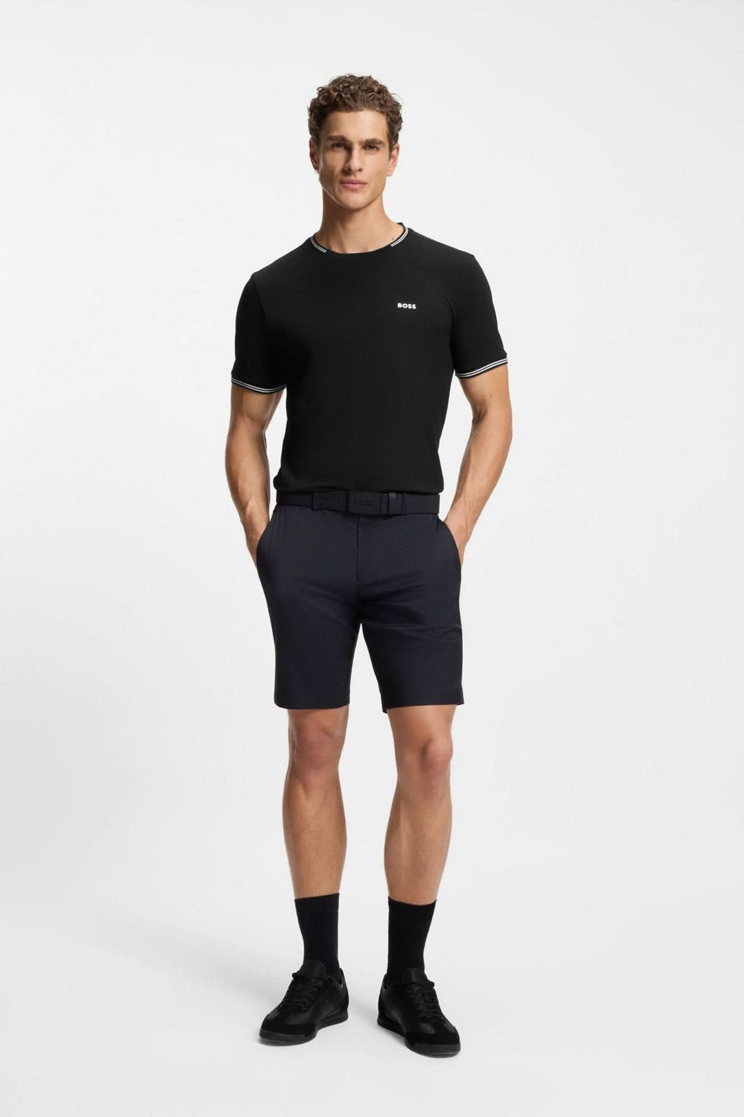 Homme portant un T-shirt essentiel à manches courtes noir, avec un look moderne et minimaliste.