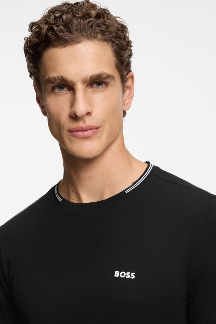 Homme portant un T-shirt essentiel à manches courtes de couleur noire avec logo Boss, coupe ajustée et détails contrastants au col.