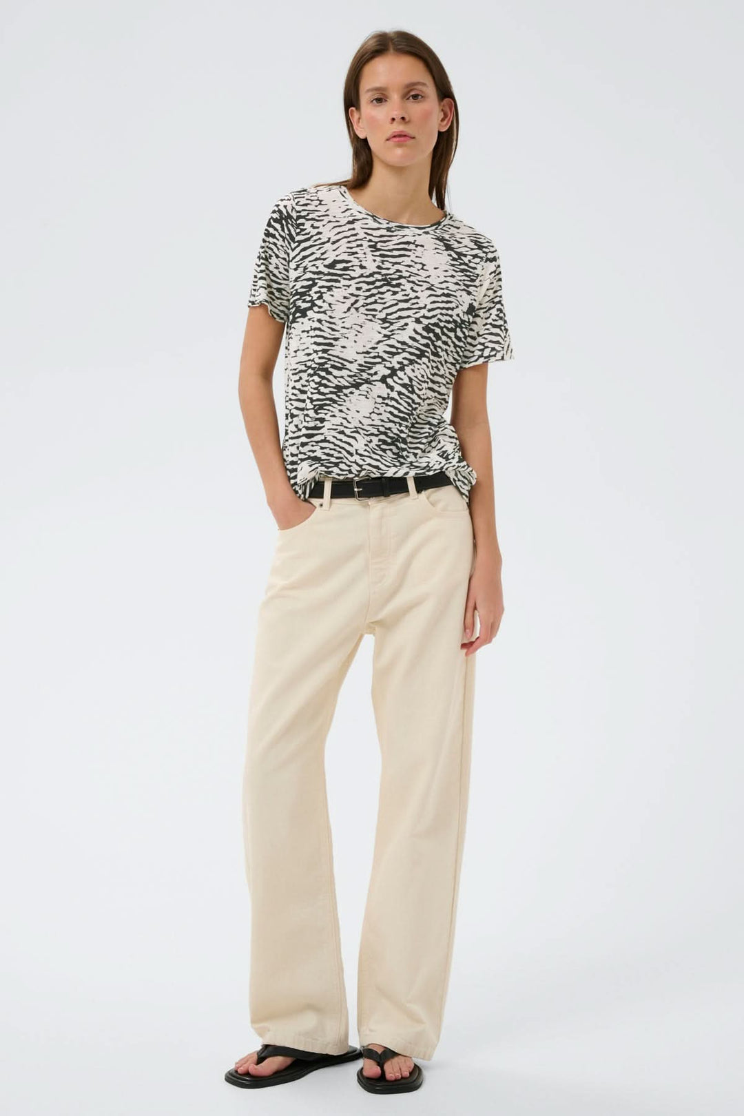 Femme portant un T-shirt imprimé Alma à coupe droite avec imprimé graphique, style décontracté, manches courtes, encolure ronde.