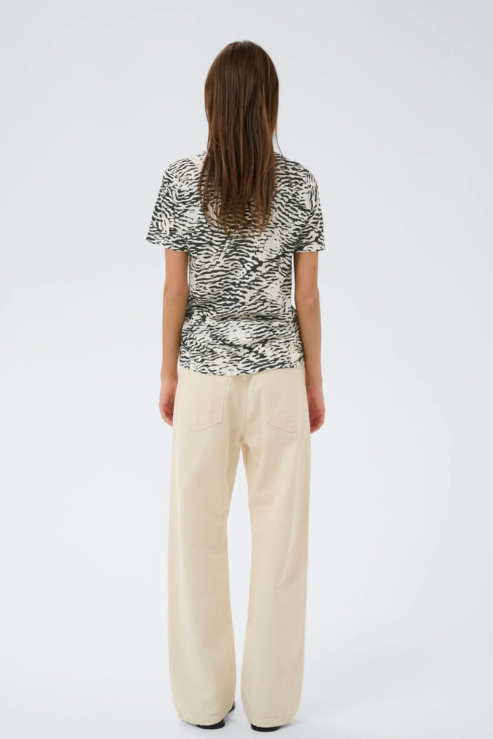 Vue arrière du T-shirt imprimé Alma avec motif graphique, manches courtes, coupe droite, et tissu confortable porté par une femme.