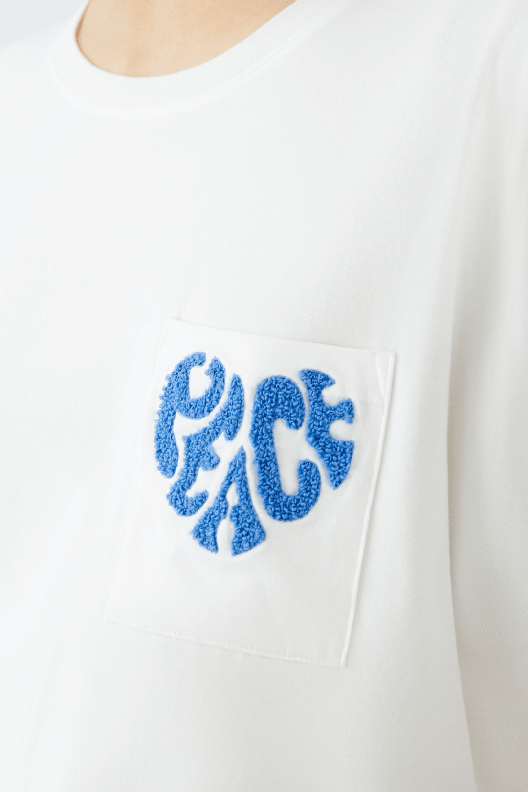 T-shirt blanc avec broderie « Peace » en tricot éponge sur la poche poitrine, élégant et confortable.