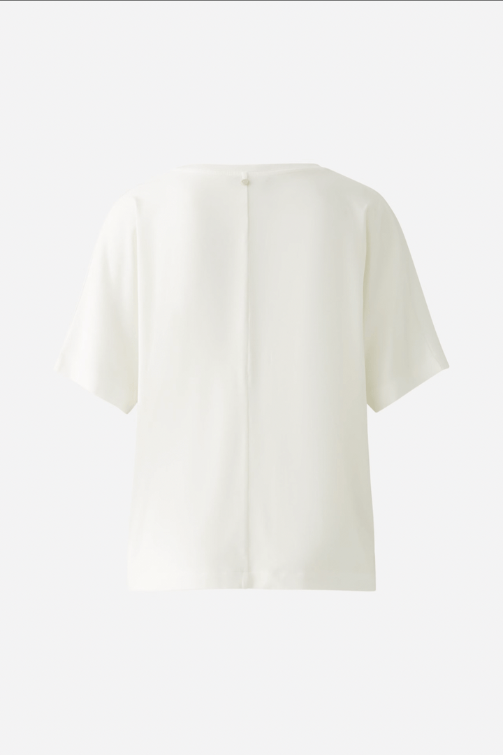 T-shirt blanc avec manches courtes et décolleté au dos, idéal pour un look casual et confortable.