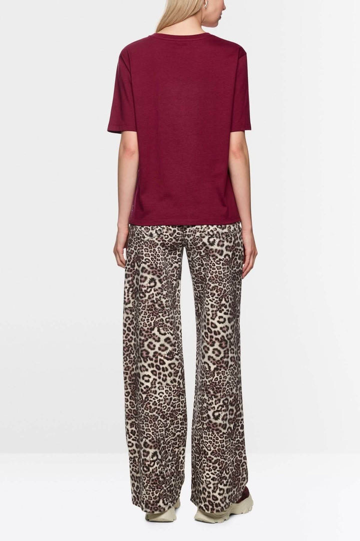Dos d'une femme portant un T-shirt imprimé cerises léopard avec pantalon motif léopard, style décontracté.