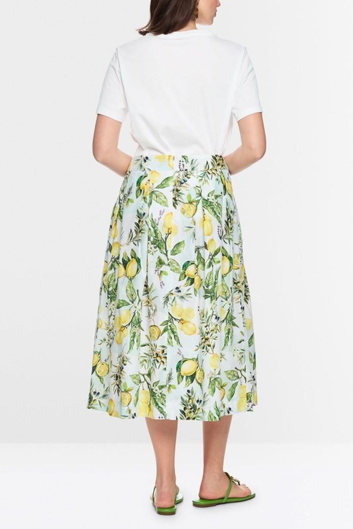 Femme portant un T-shirt imprimé citron avec une jupe motifs citrons, dos, montre un look estival et frais en coton biologique.