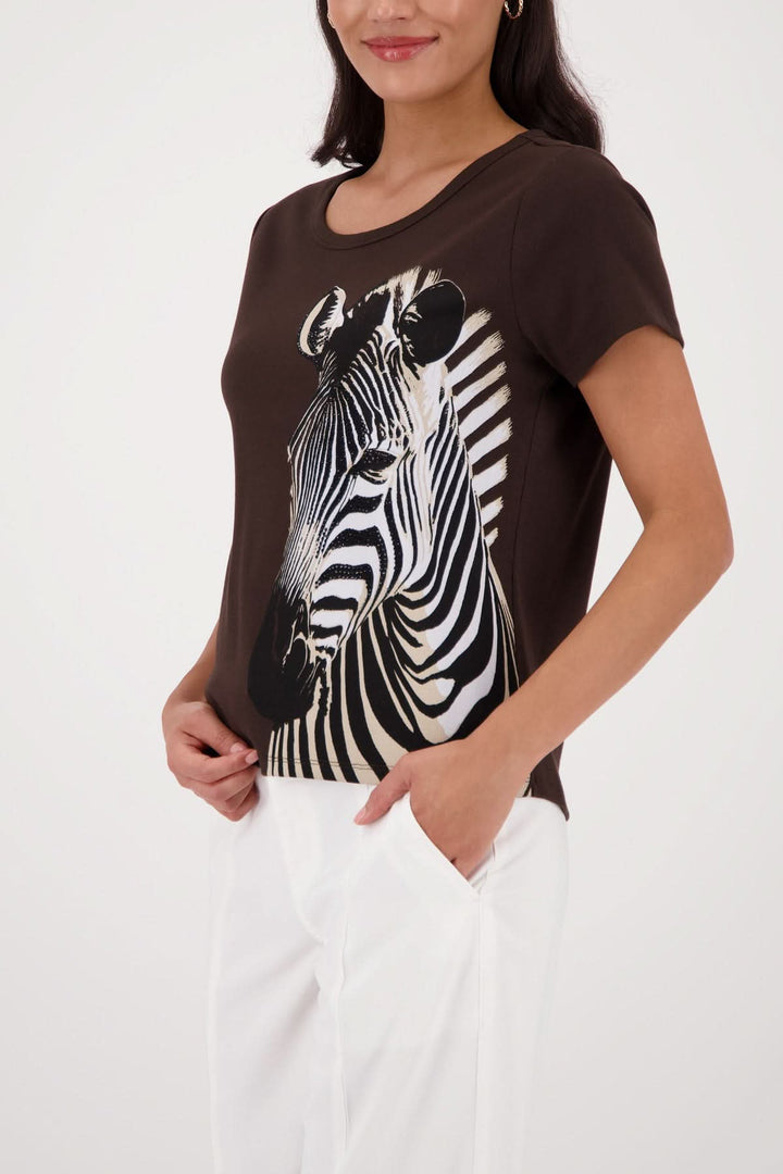 Femme portant un t-shirt imprimé zèbre avec un motif asymétrique, coupe simple et encolure arrondie.