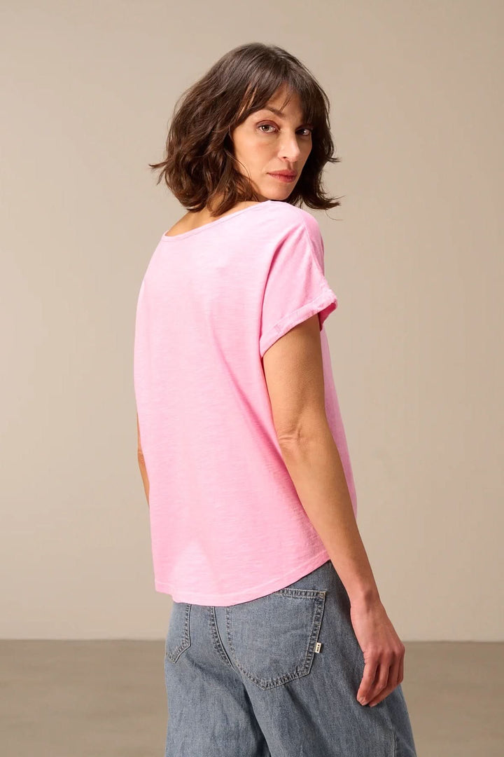 Femme portant un T-shirt à manches courtes coupe décontractée, couleur rose clair, vue de dos.