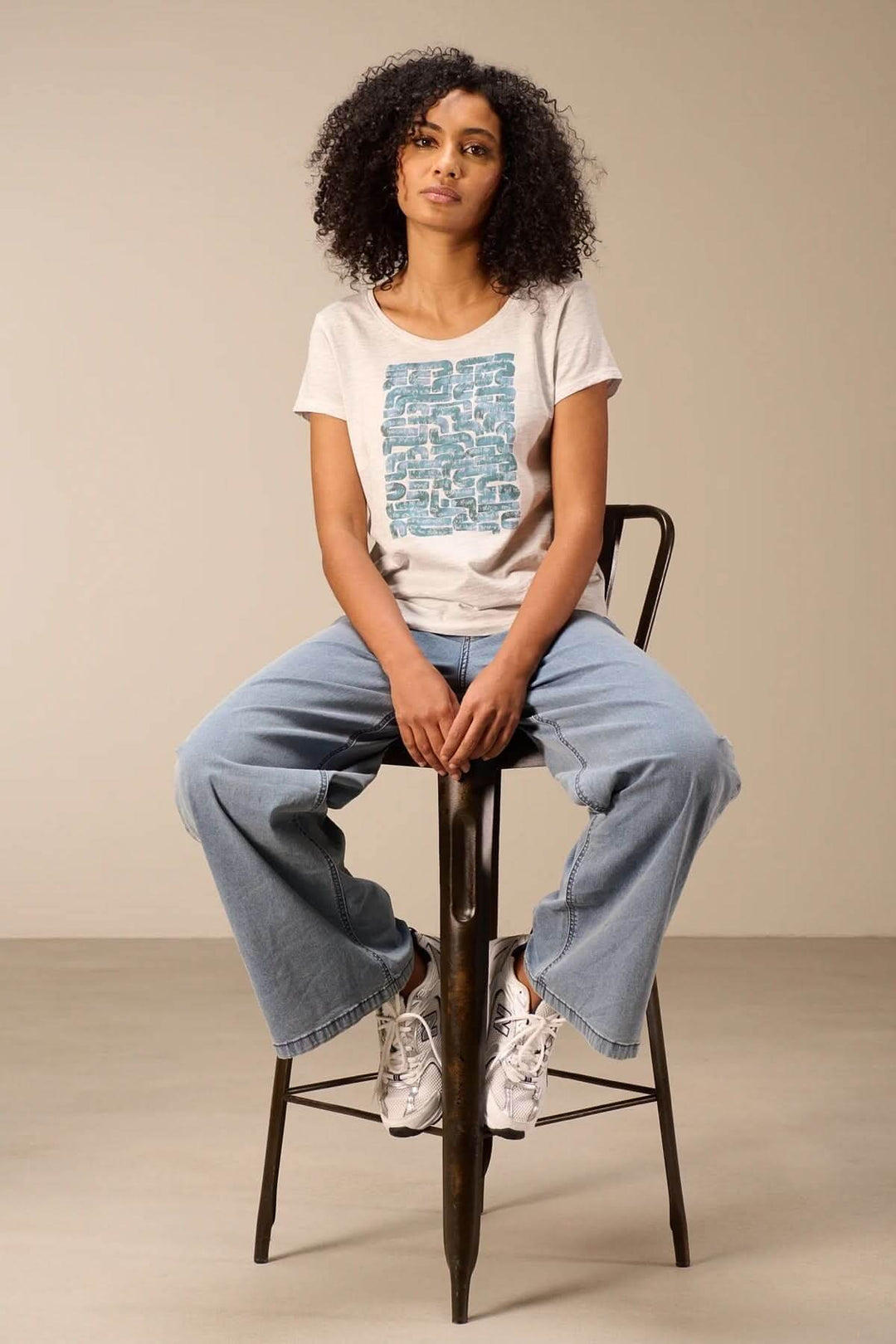 T-shirt à manches courtes coupe décontractée porté par un modèle assis, style décontracté