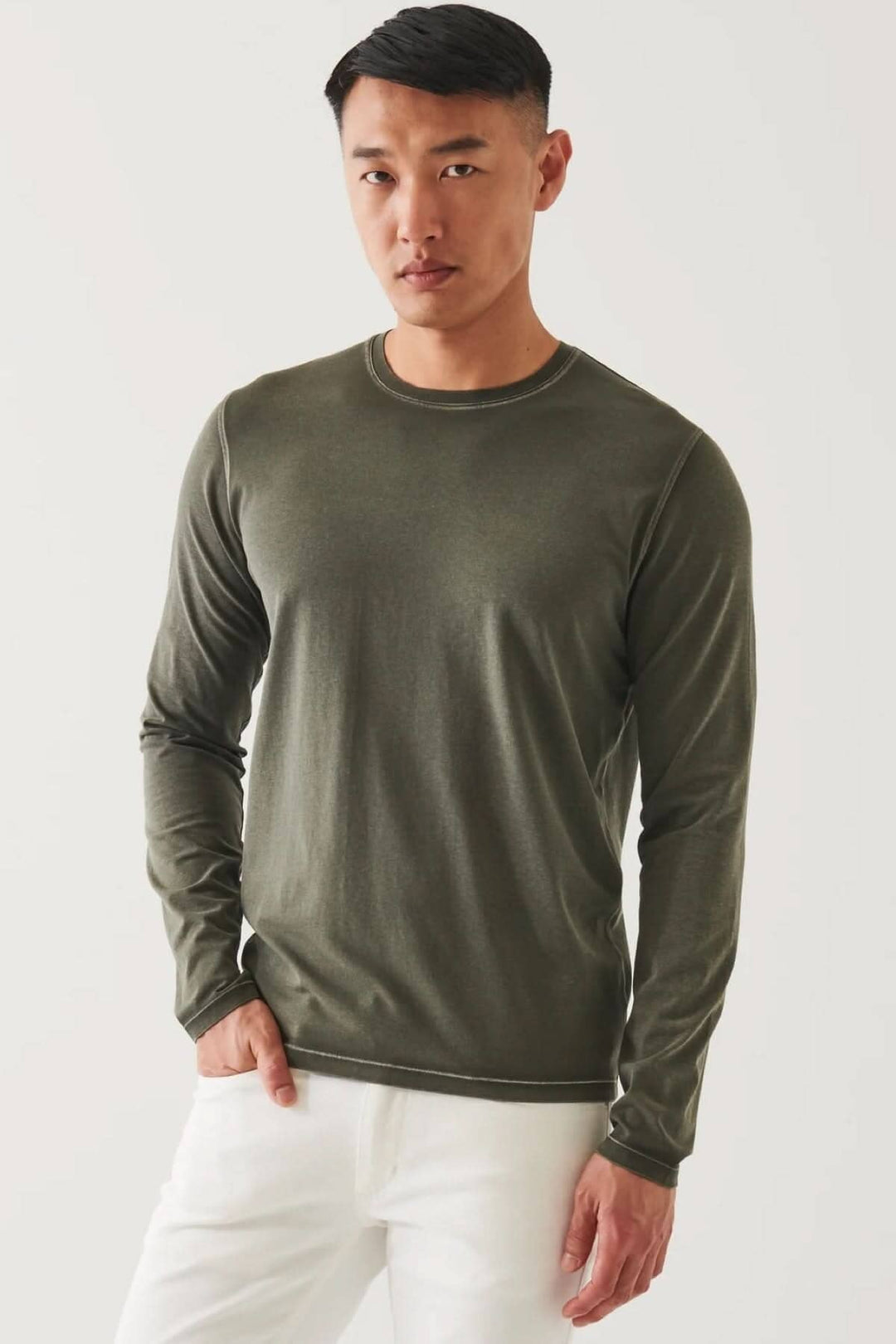 Homme portant un t-shirt à manches longues en coton pima, couleur olive, sur fond neutre.