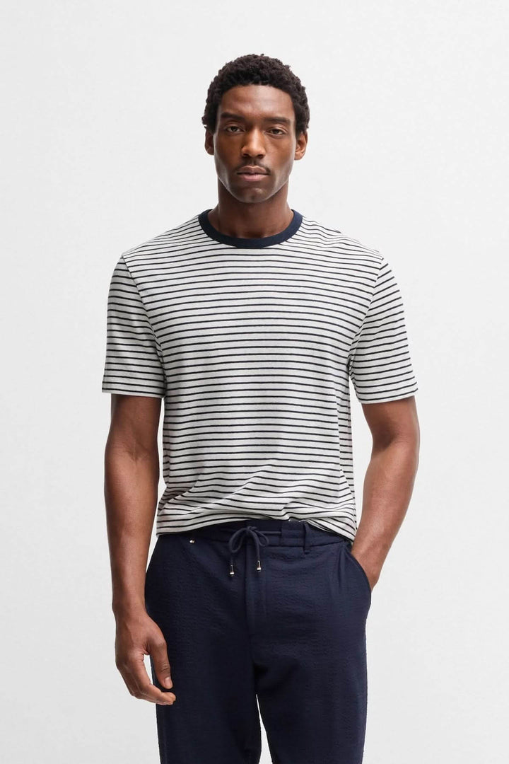 Homme portant un t-shirt rayé à col contrastant, avec un look décontracté et moderne.