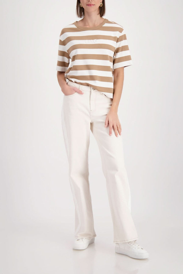 Femme portant un T-shirt rayé à logo embossé, manches courtes et tissu doux, coupe décontractée pour un look casual chic.