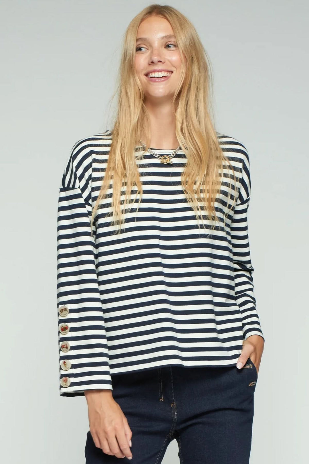 Femme portant un T-shirt rayé à manches longues avec boutons décoratifs, style décontracté et élégant, idéal pour un confort quotidien.