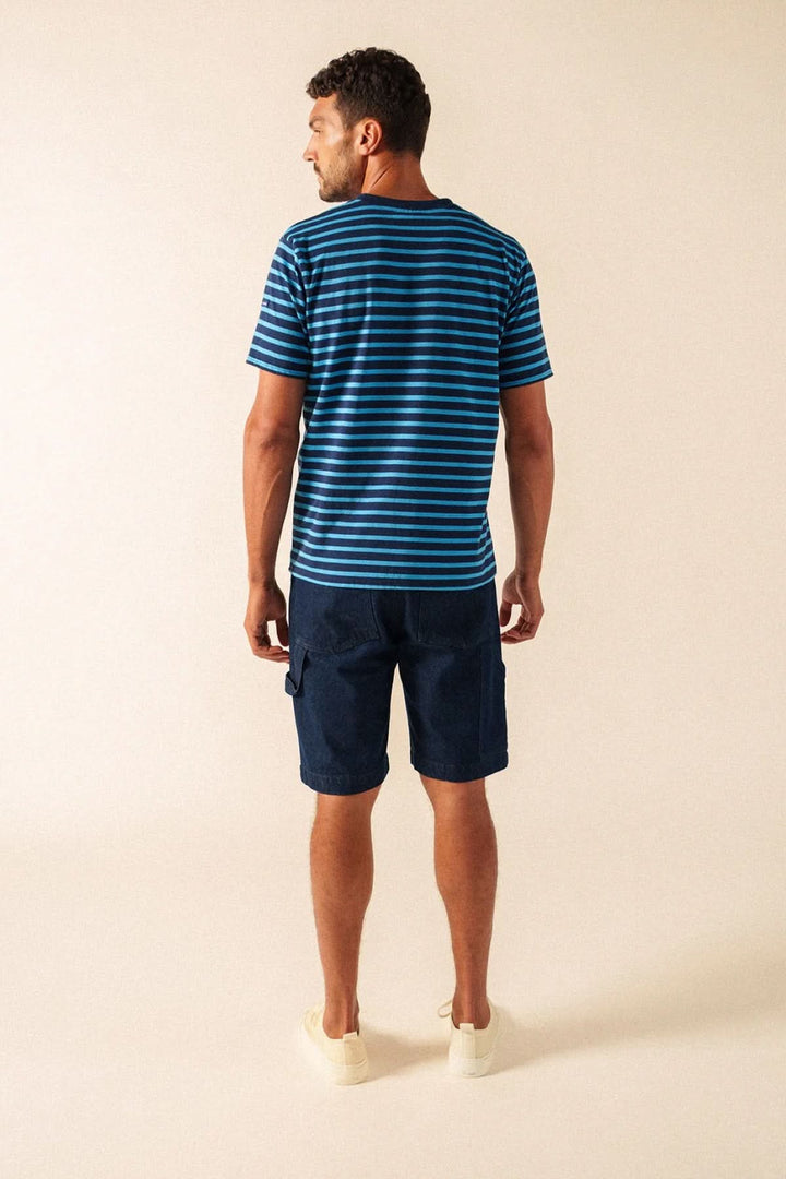 Homme portant un T-shirt à rayures classique bleu avec short décontracté vu de dos.