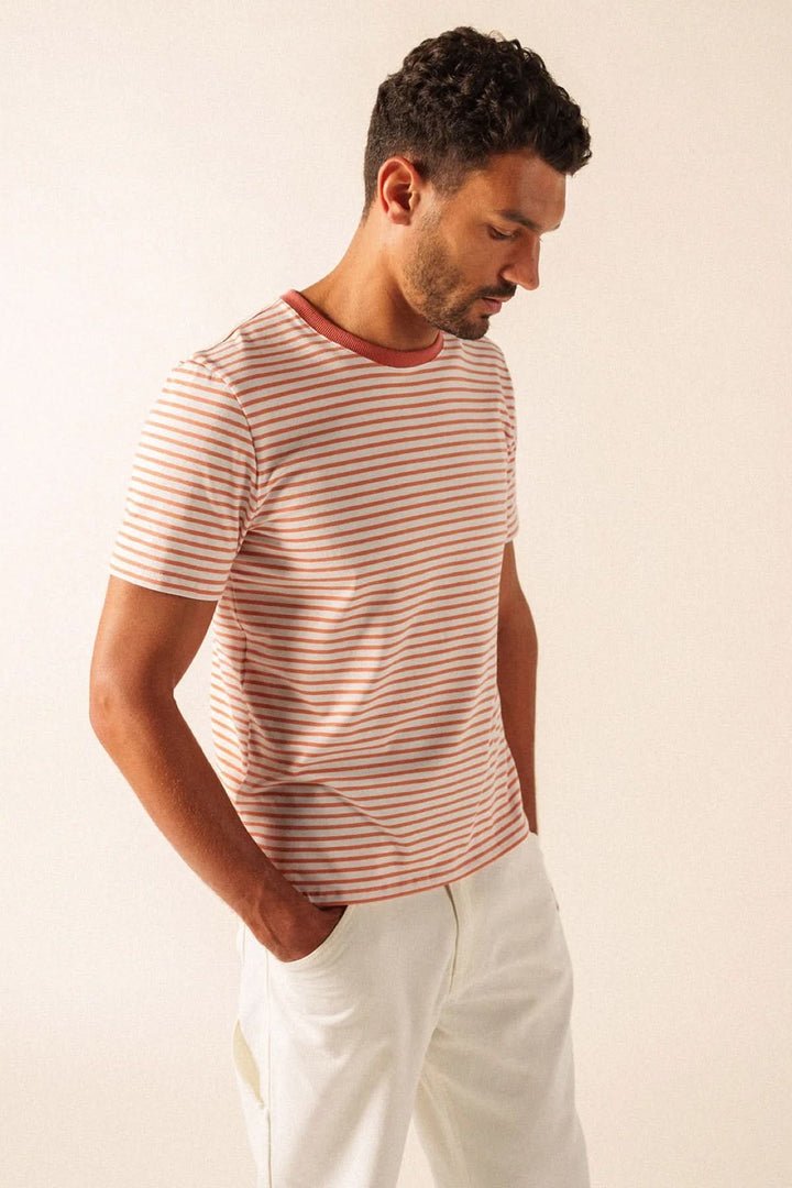 Homme portant un T-shirt à rayures fines, coupe régulière et manches courtes, style décontracté et soigné.