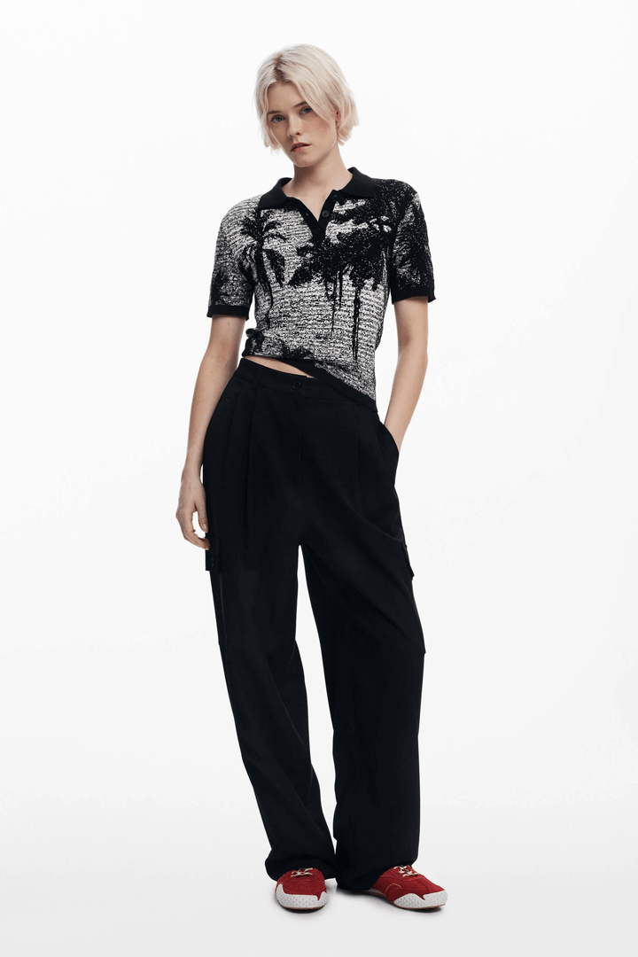 T-shirt style polo à motif paysage, porté avec un pantalon noir, look décontracté et élégant.