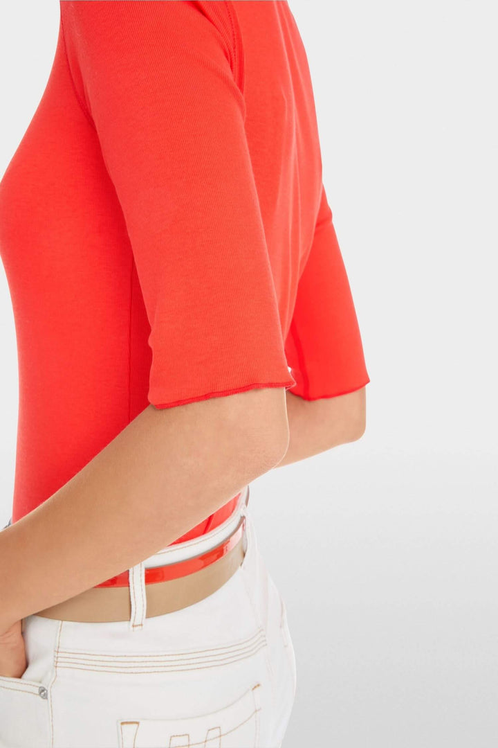 Side view of a close-fitting stretch cotton t-shirt in bright red with 3/4 sleeves, paired with white jeans.
