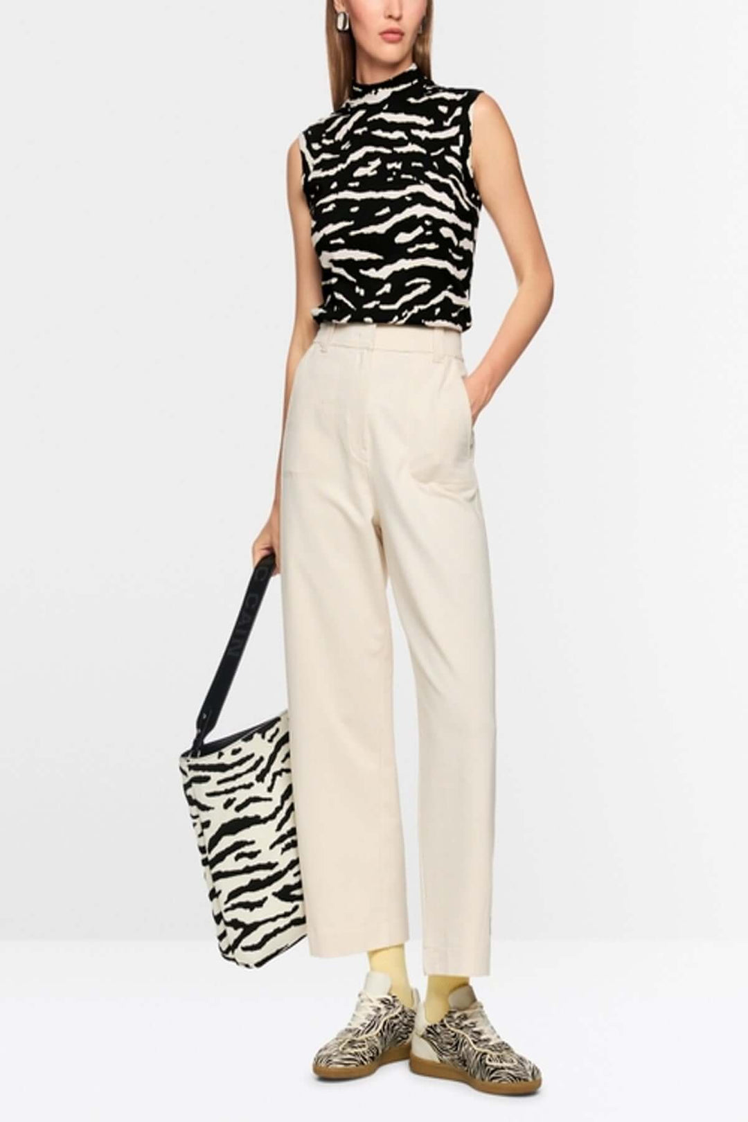 Top avec imprimé animalier sans manches sur modèle, coupe près du corps, col montant, tricot côtelé, look tendance.