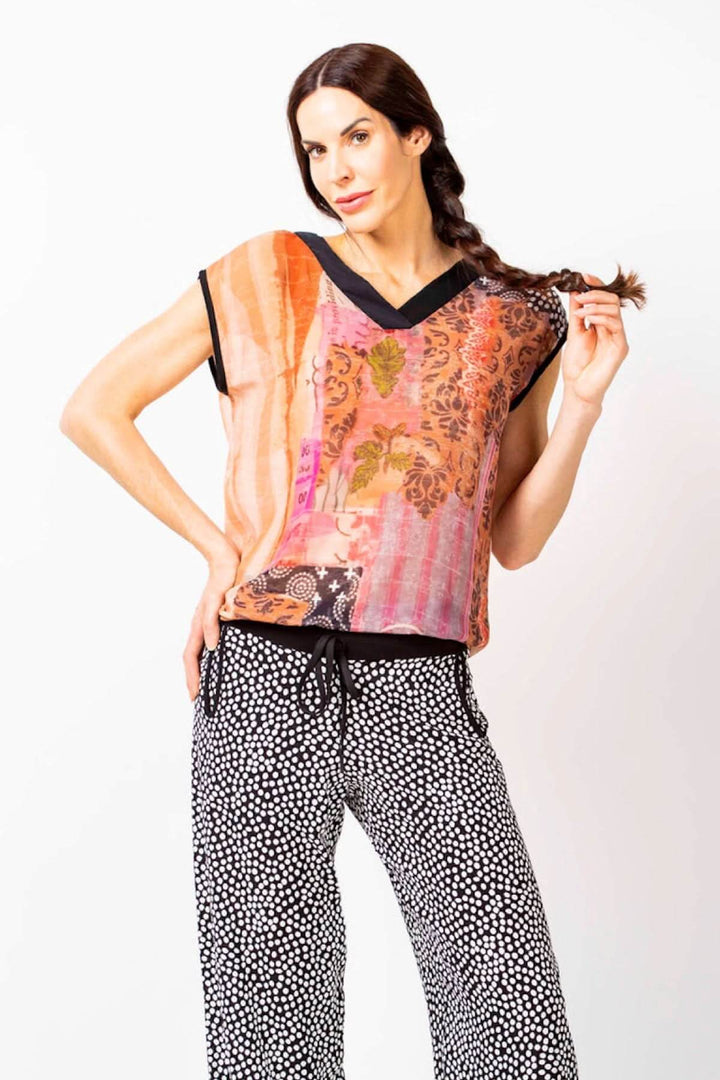 Modèle portant un top imprimé à manches courtes en chiffon léger, avec pantalons à motifs contrastants.