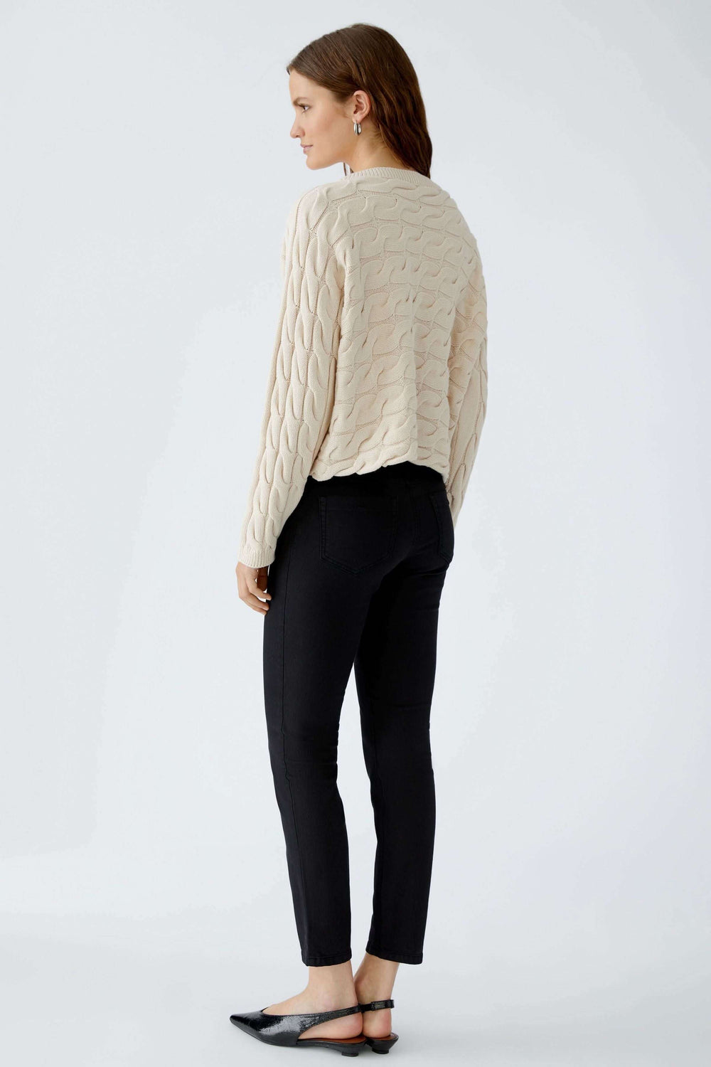 Femme portant le Tricot Sirah à motif torsadé, coupe carrée, col bateau.